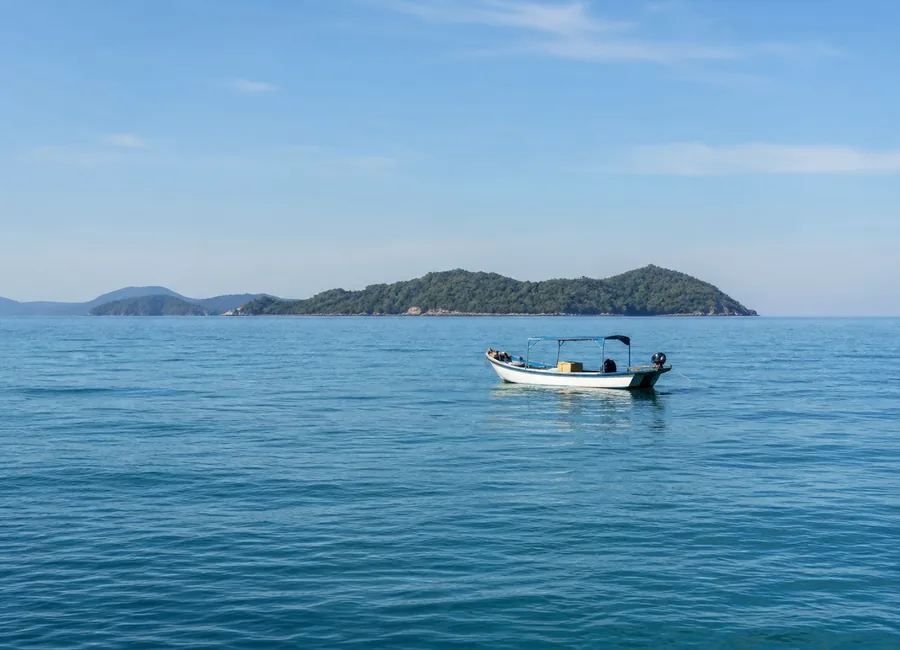 Small boat crossing calm tropical water